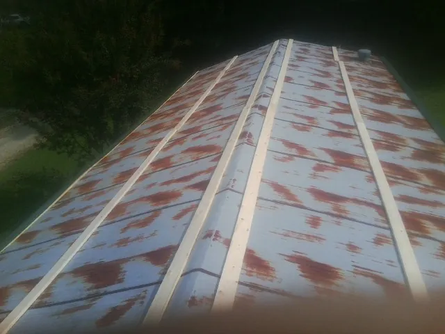 Rusted metal roof panels with new wood purlins before replacement — Storm Damage Roof Repair in Blythe by Roofing Brothers