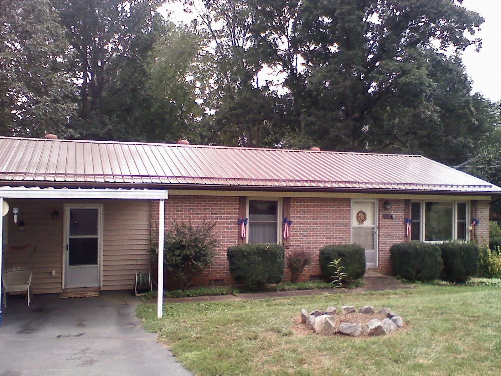 Bronze metal roof and carport on a brick ranch home — Roof Repair work by our crew in Blythe